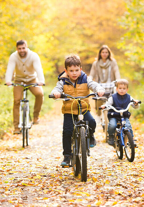 Familia manejando bicicleta en otonño