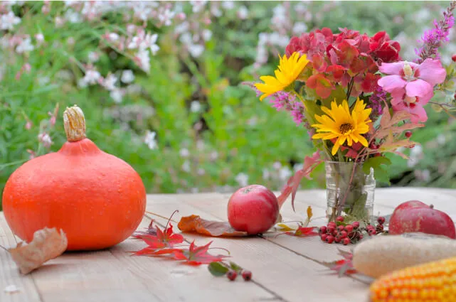 Imagen de unas flores otoñales sobre una mesa de madera