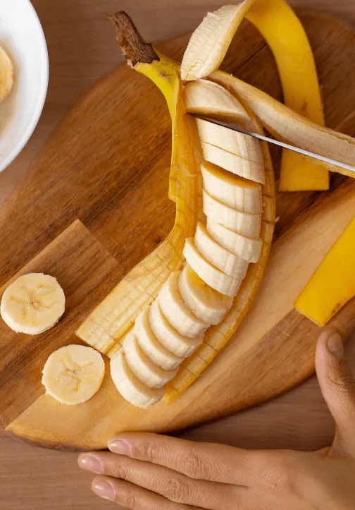 persona cortando plátano en una tabla