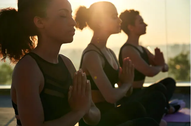 Personas realizando una postura de yoga como actividad en otoño