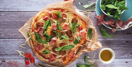 Pizza de jamón serrano con rucula, tomate
