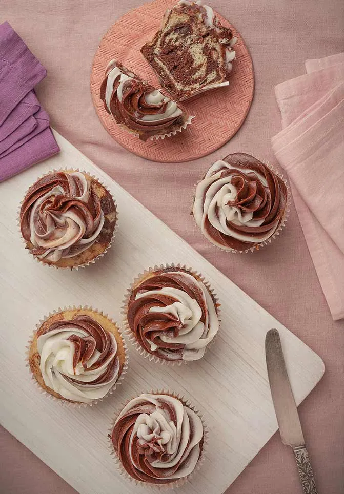 tabla con cupcakes con frosting bicolor y queque de marmol selecta